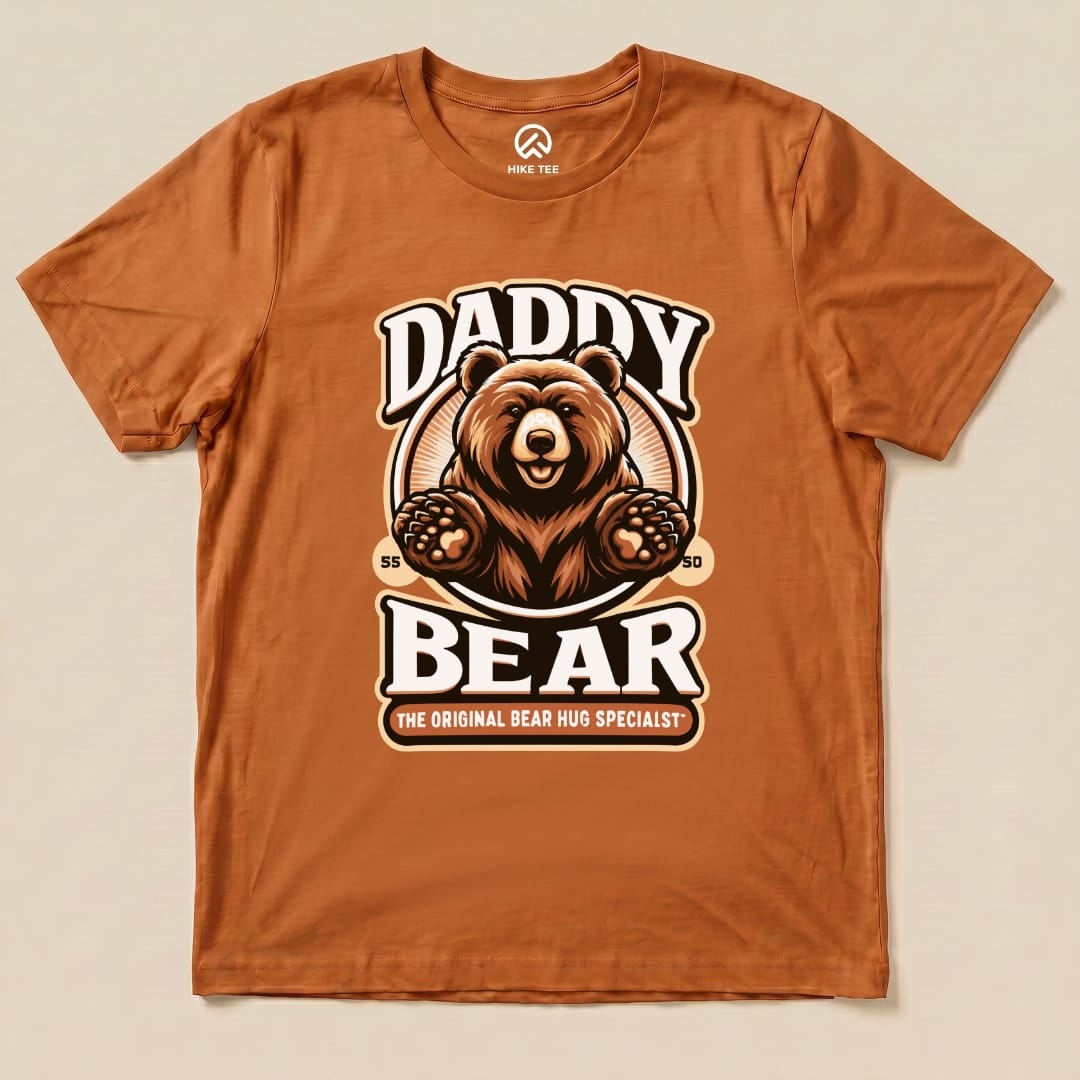 The "Hug Daddy Bear Shirt" features a playful graphic of a bear with the text "DADDY BEAR" and "THE ORIGINAL BEAR HUG SPECIALIST" on a rust-colored tee.