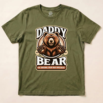 A graphic t-shirt featuring a friendly bear with the text "Daddy Bear" and "The Original Bear Hug Specialist," in earthy tones.