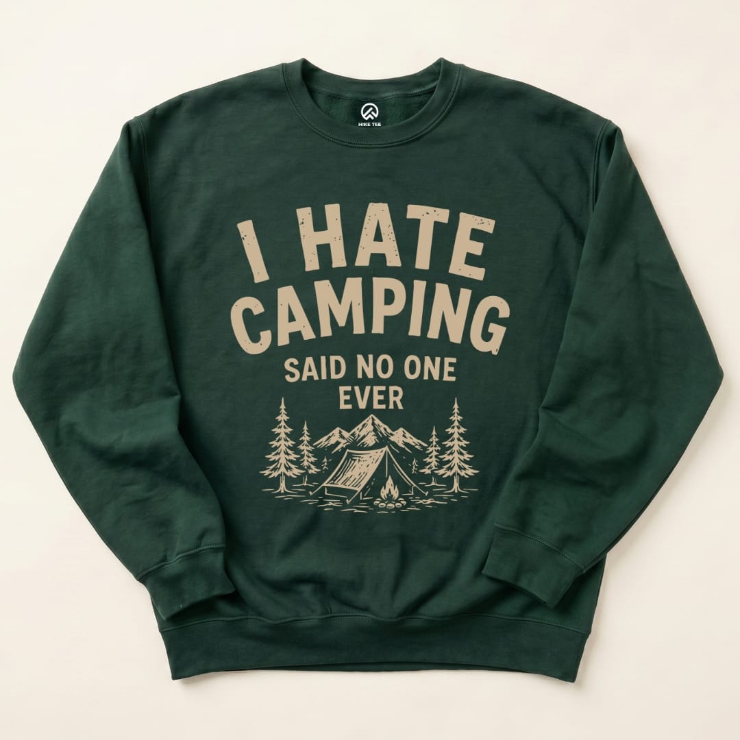 A dark green sweatshirt featuring the phrase "I HATE CAMPING SAID NO ONE EVER" along with a mountain and tent graphic.
