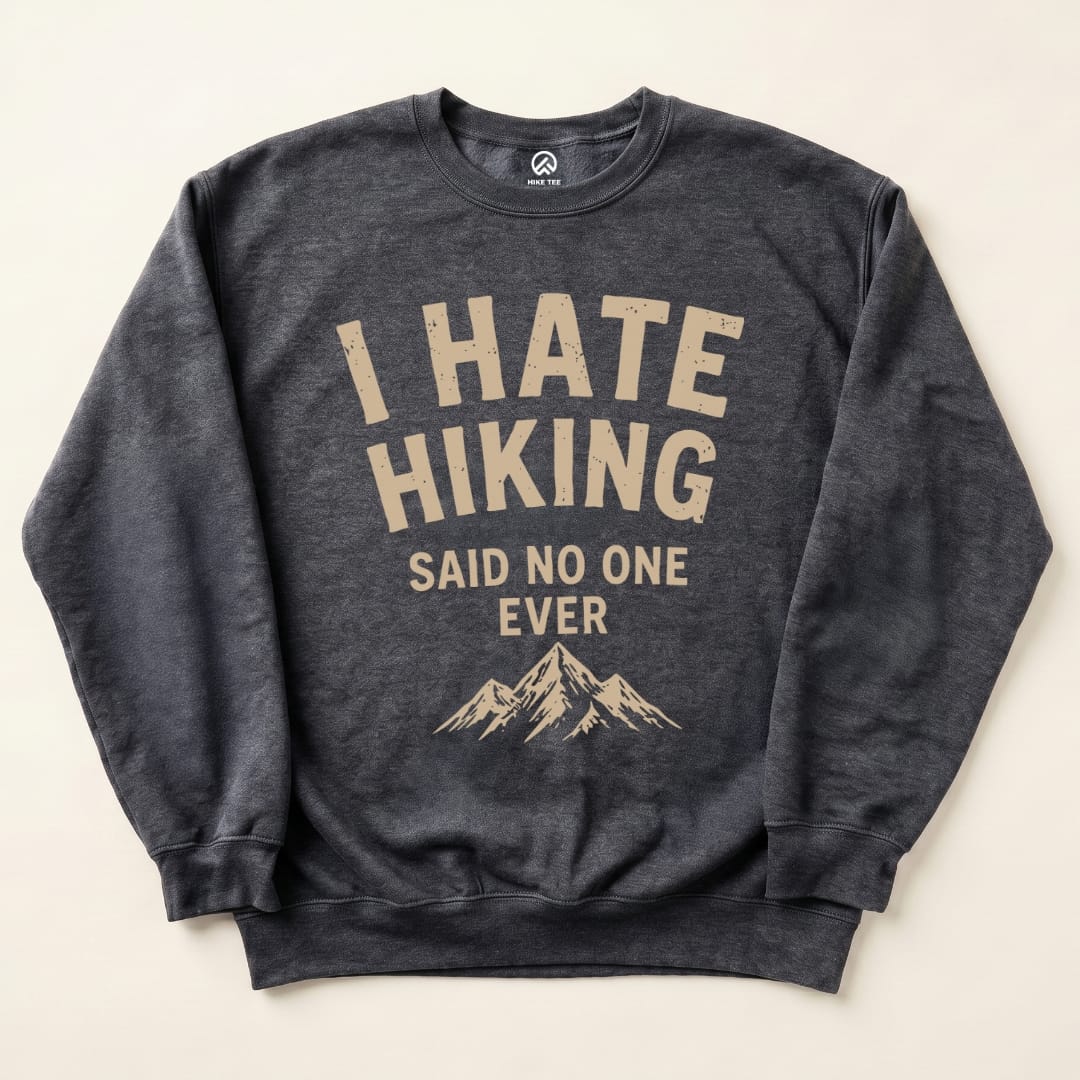 A dark gray "I Hate Hiking Sweatshirt" featuring the slogan in large, bold letters with a mountain graphic below.