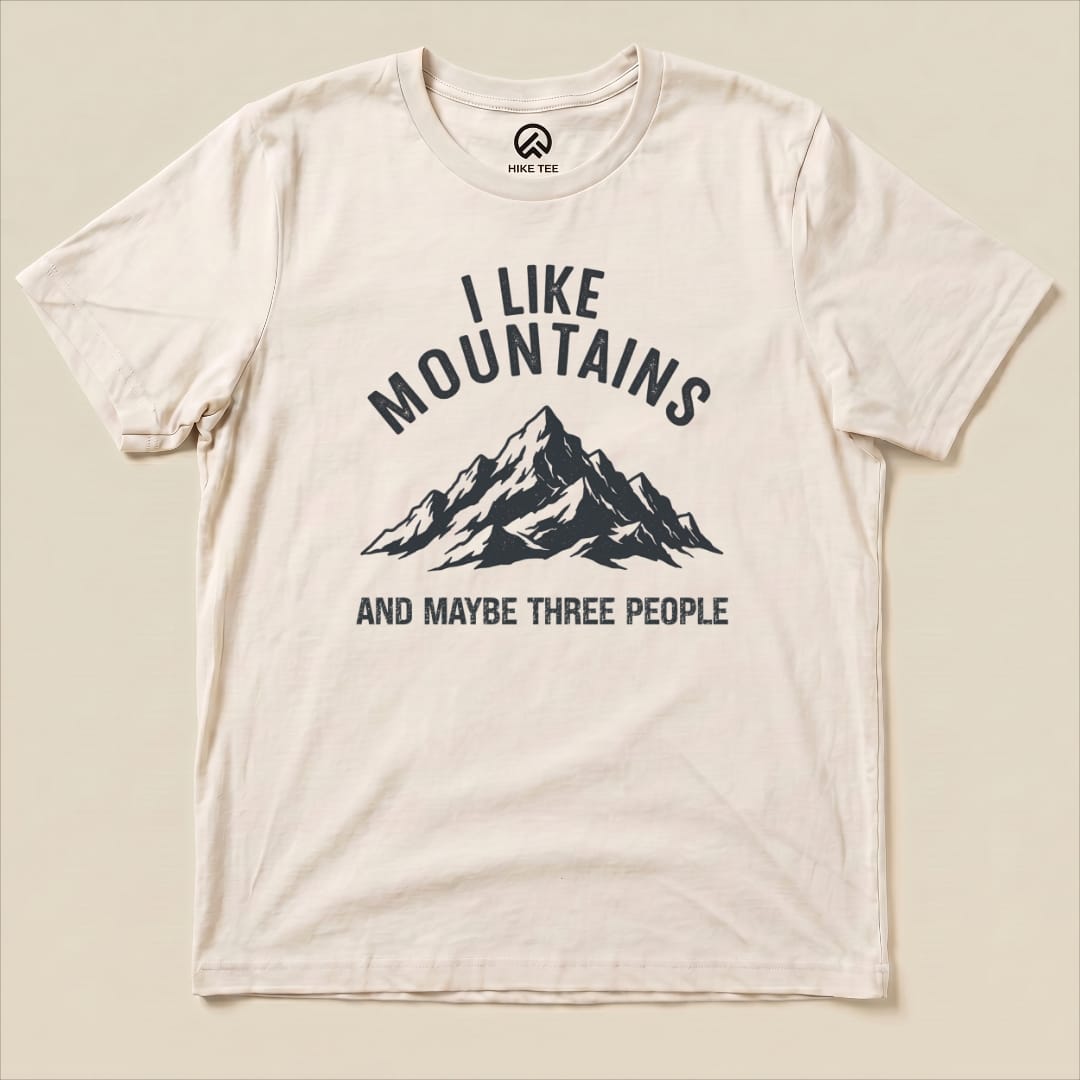 The image features a flat "I Like Mountains Shirt" with a graphic of a mountain and the phrase "I LIKE MOUNTAINS AND MAYBE THREE PEOPLE.