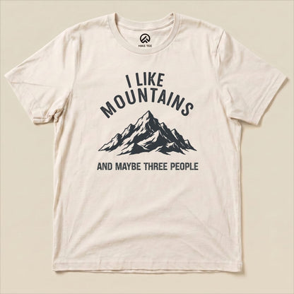 The image features a flat "I Like Mountains Shirt" with a graphic of a mountain and the phrase "I LIKE MOUNTAINS AND MAYBE THREE PEOPLE.
