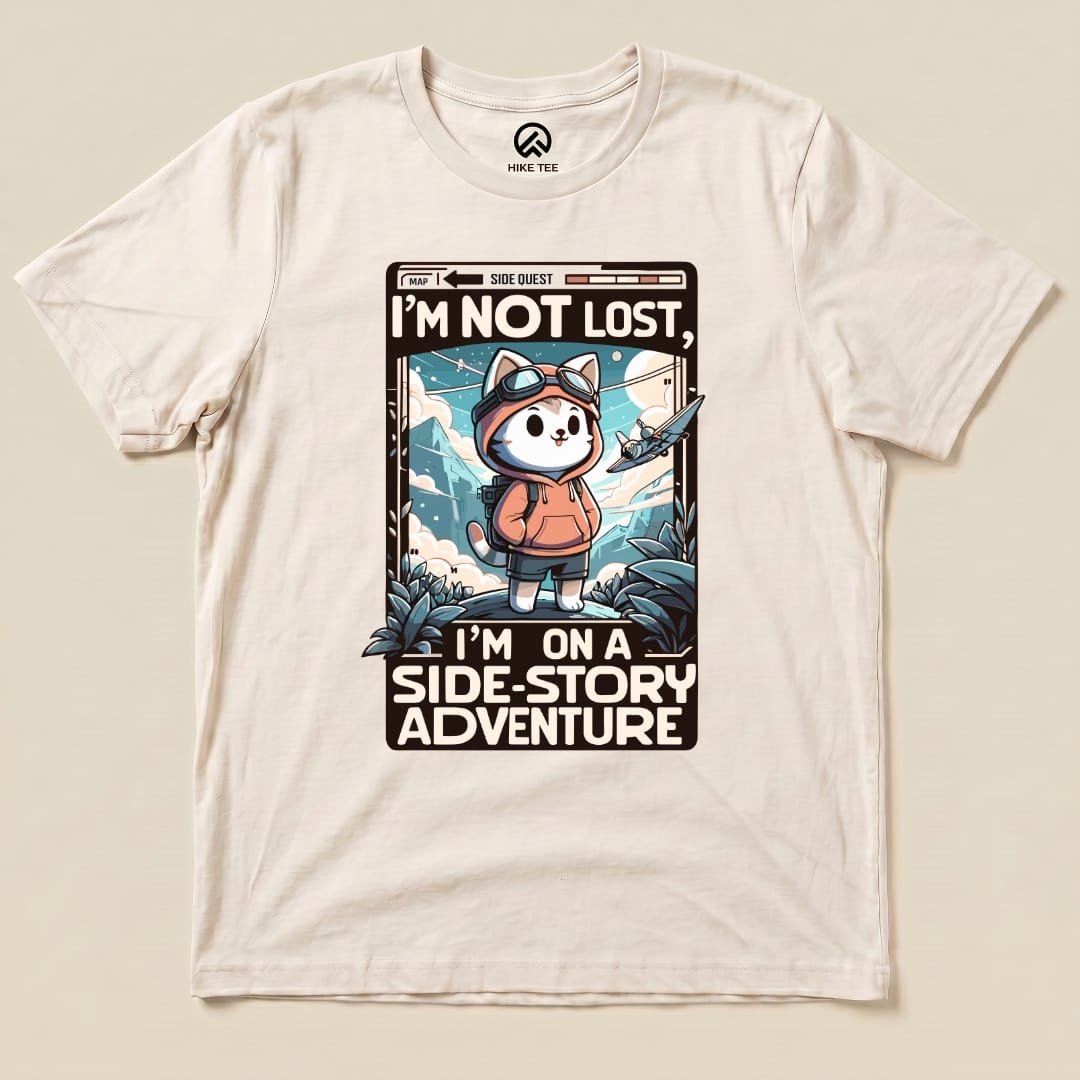 The "I'm Not Lost Cat Shirt" features a cute cat in a hoodie with the text "I'M NOT LOST, I'M ON A SIDE-STORY ADVENTURE" and vibrant outdoor elements.