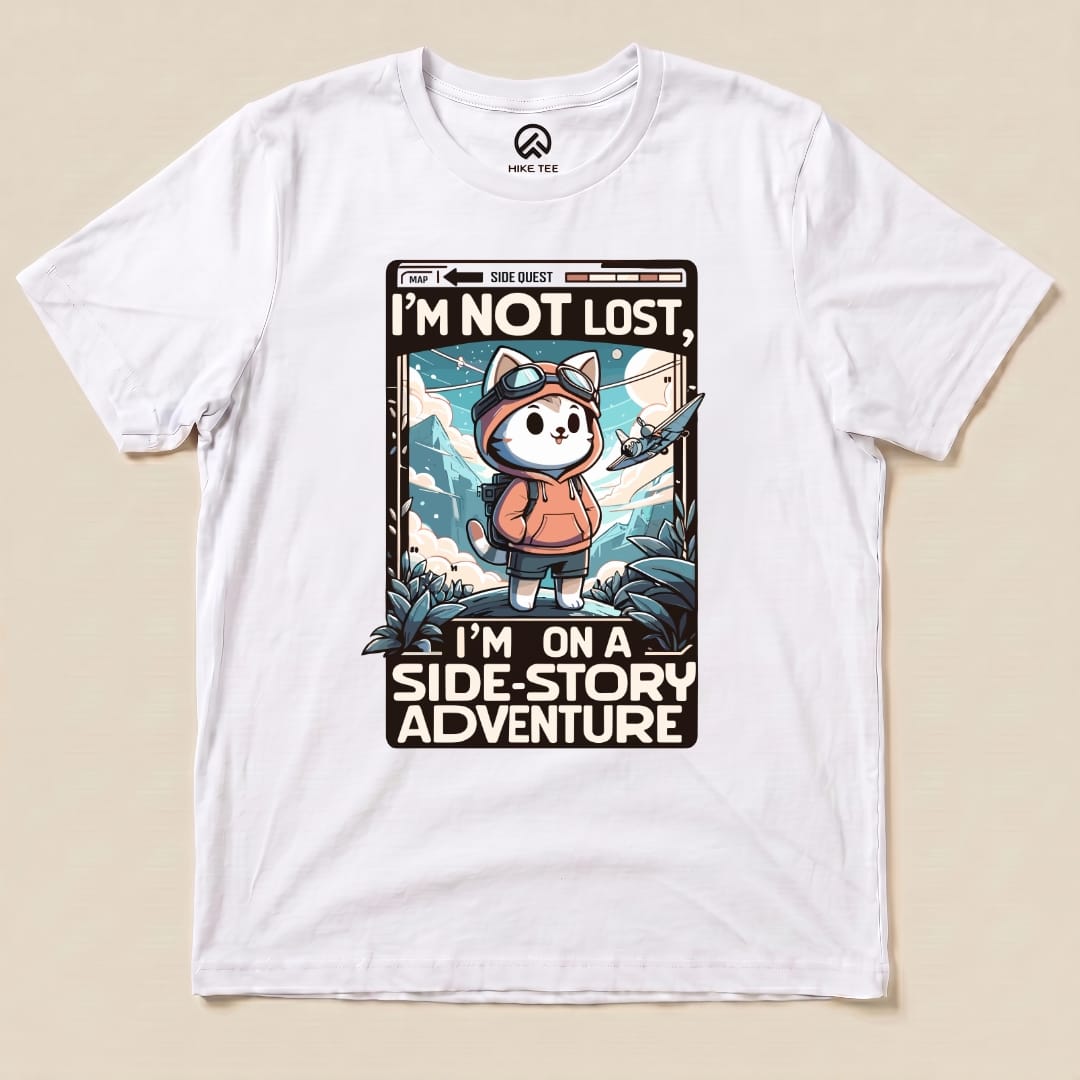 Graphic t-shirt featuring a playful cartoon design of a cat in a hoodie with text that says, "I'm Not Lost, I'm on a Side-Story Adventure.