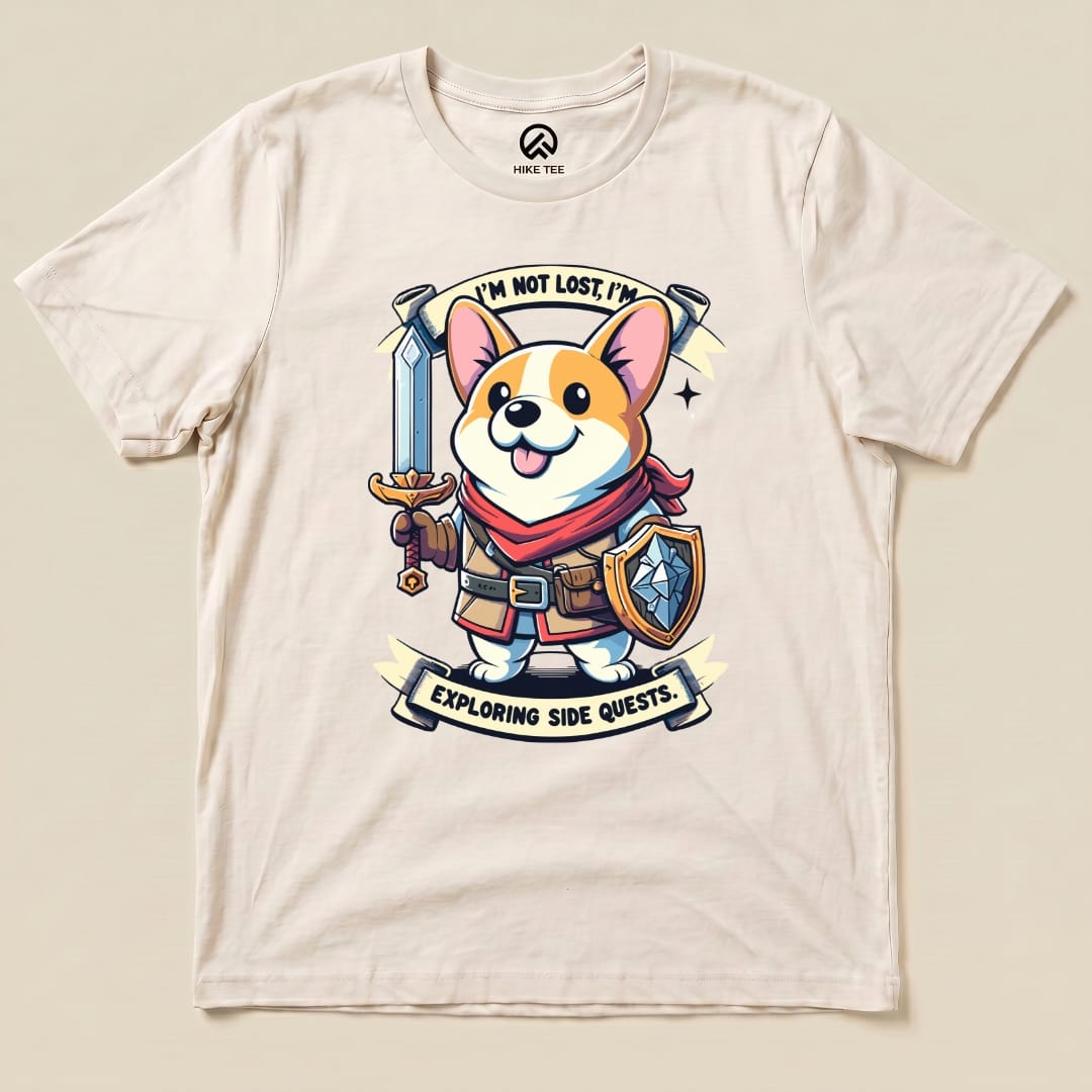 A graphic t-shirt featuring a cheerful corgi with a sword and shield, captioned "I'm Not Lost, I'm Exploring Side Quests.