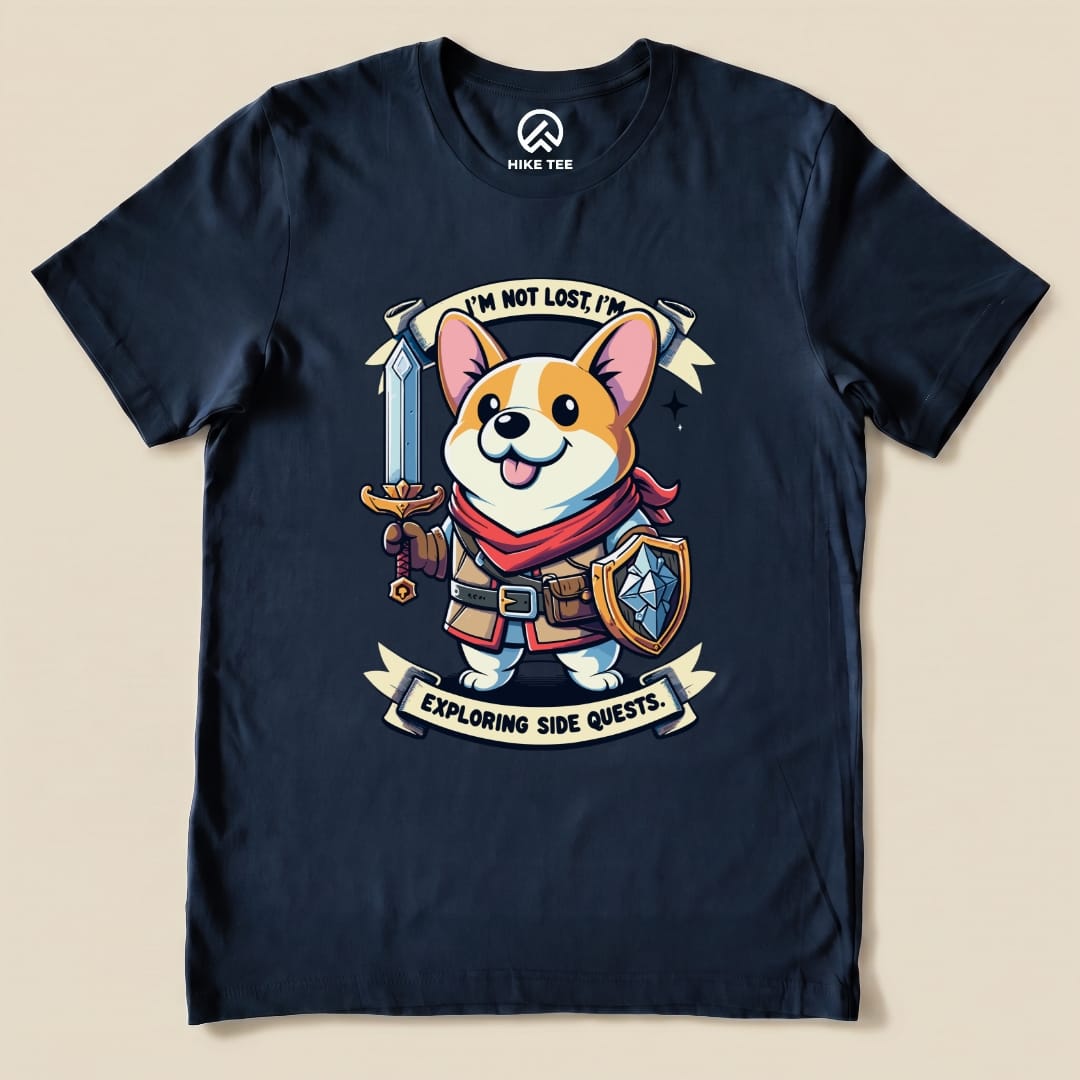 A navy graphic t-shirt featuring a cheerful corgi with a sword and shield, printed with the phrase "I'm Not Lost, I'm Exploring Side Quests.