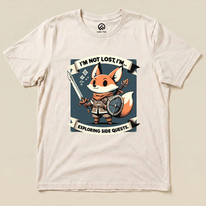 Graphic t-shirt featuring a cheerful fox character holding a sword and shield, with the slogan "I'm Not Lost, I'm... Exploring Side Quests.