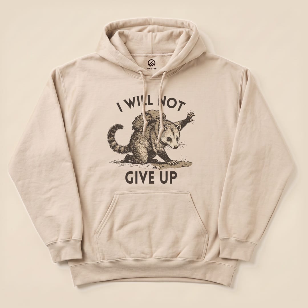 A beige hoodie featuring an opossum graphic with the text "I WILL NOT GIVE UP," part of the "I Will Not Possum Hoodie" design.
