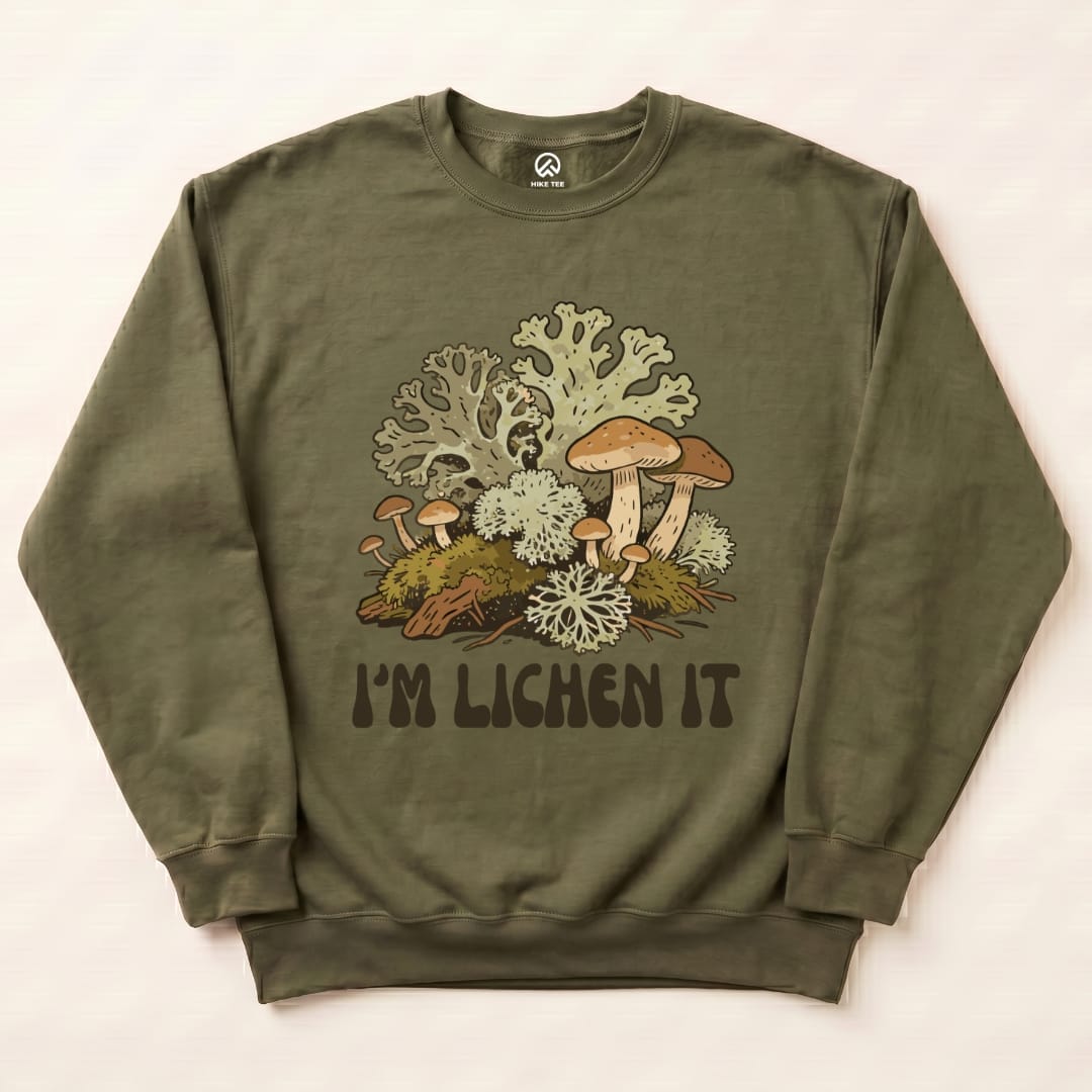 An olive-green sweatshirt featuring a graphic of mushrooms and lichen with the text "I'm Lichen It" below the design.