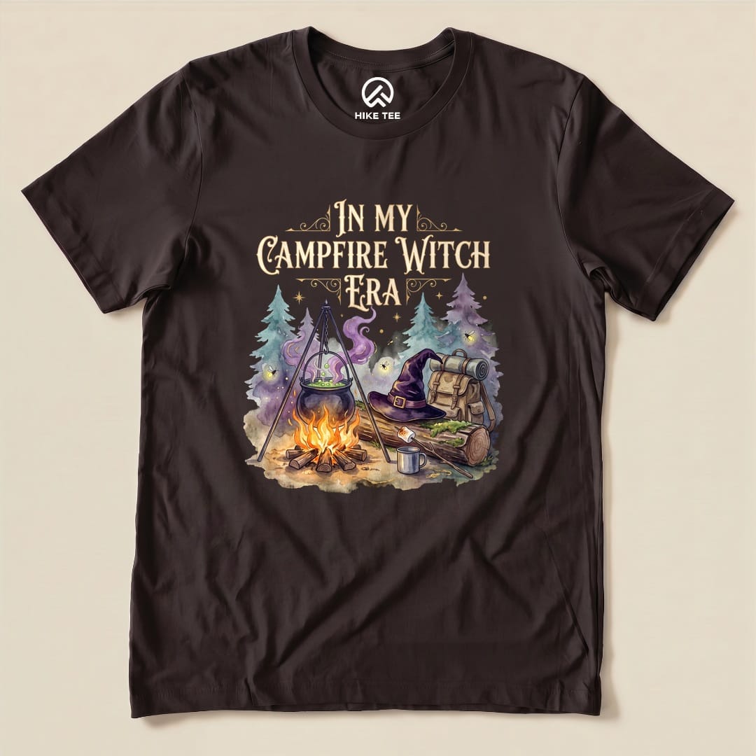 Brown In My Campfire Witch Era Shirt with a witch cauldron over a campfire with a witch hat and backpack graphic