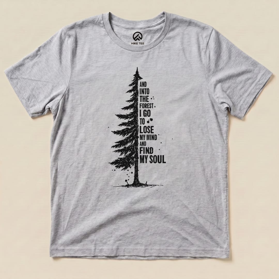 A light gray graphic t-shirt from Hike Tee features a tall tree illustration and the phrase "And into the forest I go to lose my mind and find my soul," titled "In The Forest Shirt.