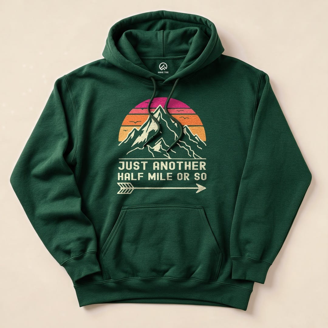 A green "Just Another Half Mile Hoodie" features a mountain graphic with a colorful sunset and the text "JUST ANOTHER HALF MILE OR SO.