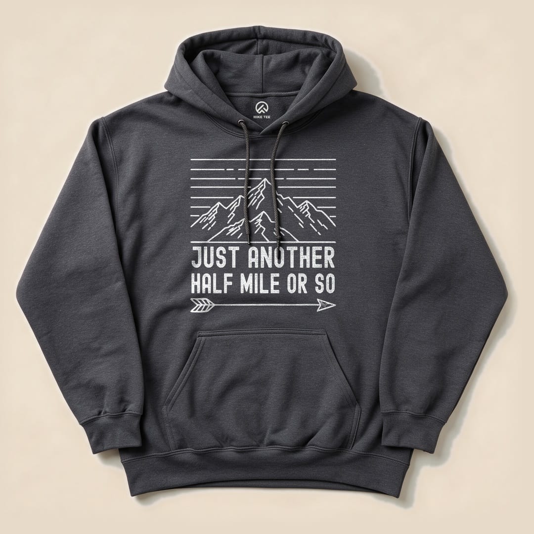 A dark gray hoodie featuring a mountain graphic and the slogan "Just Another Half Mile Or So" printed in white.