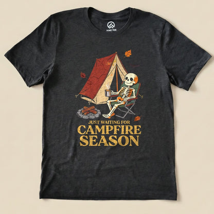 Dark Grey Heather Just Waiting for Campfire Season Shirt with a skeleton in a camp chair by a tent graphic