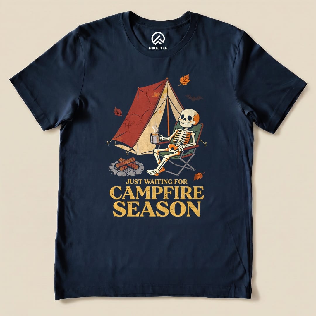 Navy Just Waiting for Campfire Season Shirt with a skeleton in a camp chair by a tent graphic