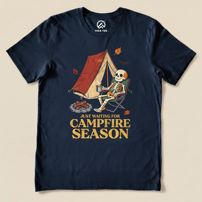Navy Just Waiting for Campfire Season Shirt with a skeleton in a camp chair by a tent graphic