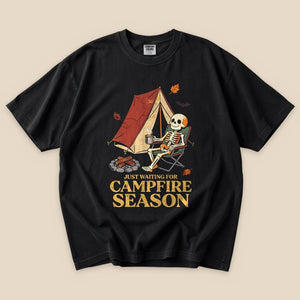 Black Just Waiting for Campfire Season T-Shirt with a skeleton in a camp chair by a tent graphic