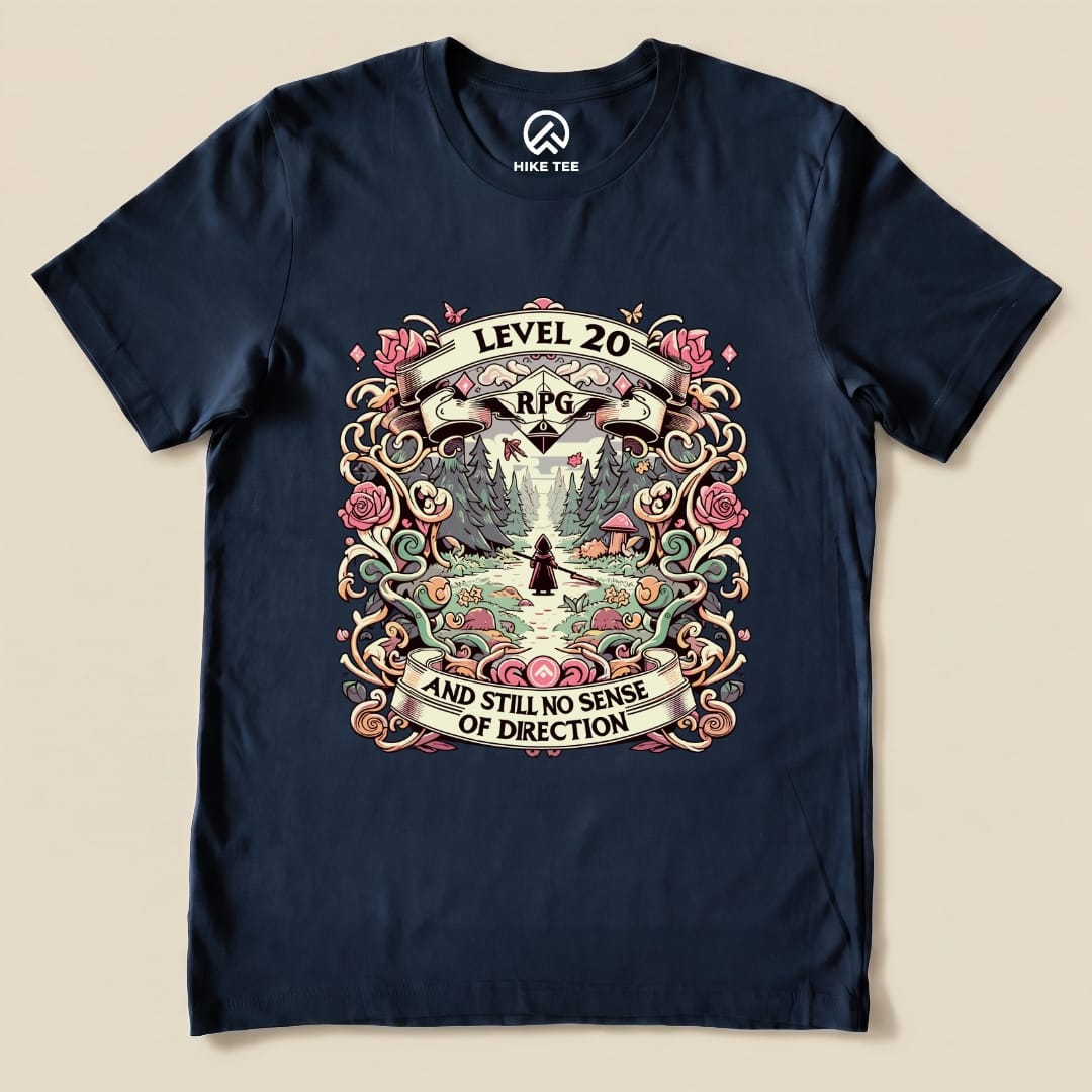 The graphic t-shirt displays a colorful design featuring the phrase "Level 20 RPG AND STILL NO SENSE OF DIRECTION" amidst a nature scene.