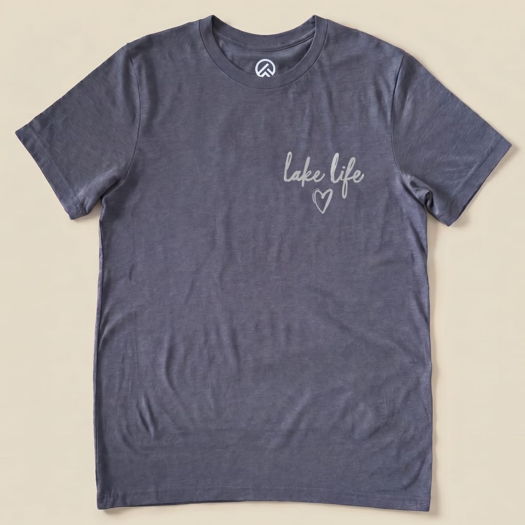 A graphic t-shirt in a slate gray color featuring the phrase "lake life" in a playful script with a small heart design.