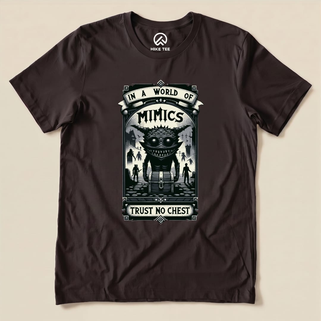 A graphic t-shirt featuring a large, humorous mimic creature and the text "In a World of Mimics, Trust No Chest.