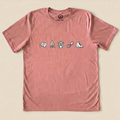 This minimalistic drawing hiking shirt features simple illustrations of a map, campfire, hiking boots, and compass on a dusty rose t-shirt.