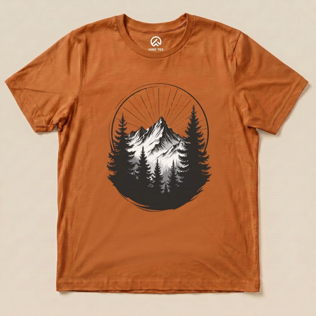 The Monochrome Mountains Shirt features a striking black and white mountain graphic surrounded by trees on a rust-colored background.