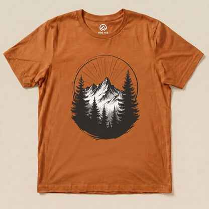 The Monochrome Mountains Shirt features a striking black and white mountain graphic surrounded by trees on a rust-colored background.