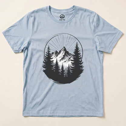 A light blue graphic t-shirt featuring the "Monochrome Mountains Shirt" design with stylized mountains and trees.