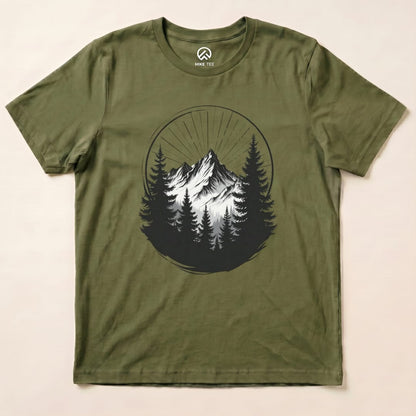 The Monochrome Mountains Shirt features a striking graphic of snowy peaks surrounded by dark trees, set against an olive green background.