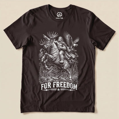 A graphic t-shirt featuring a moose, a figure, and an eagle with the slogan "FOR FREEDOM," titled the "Moose Bigfoot Resist Shirt.