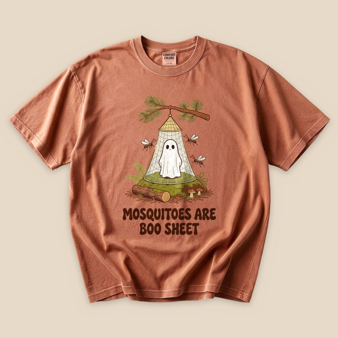 A flat graphic t-shirt in rust color features a humorous design of a ghost in a mosquito net with the text "Mosquitoes Are Boo Sheet.