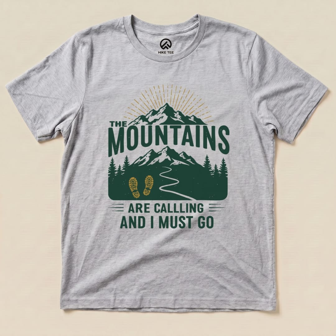 The graphic t-shirt features a design with mountains, trees, and the slogan "The Mountains Are Calling and I Must Go.