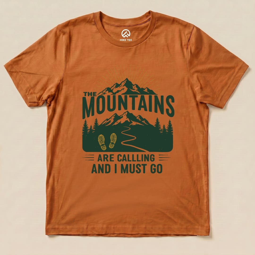 The Mountains Are Calling Shirt features a graphic design of mountains, trees, and a hiking path with the slogan "ARE CALLING AND I MUST GO".