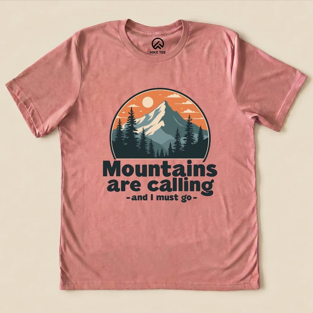 A pink graphic t-shirt features a mountain scene with the slogan "Mountains are calling - and I must go" beneath it.