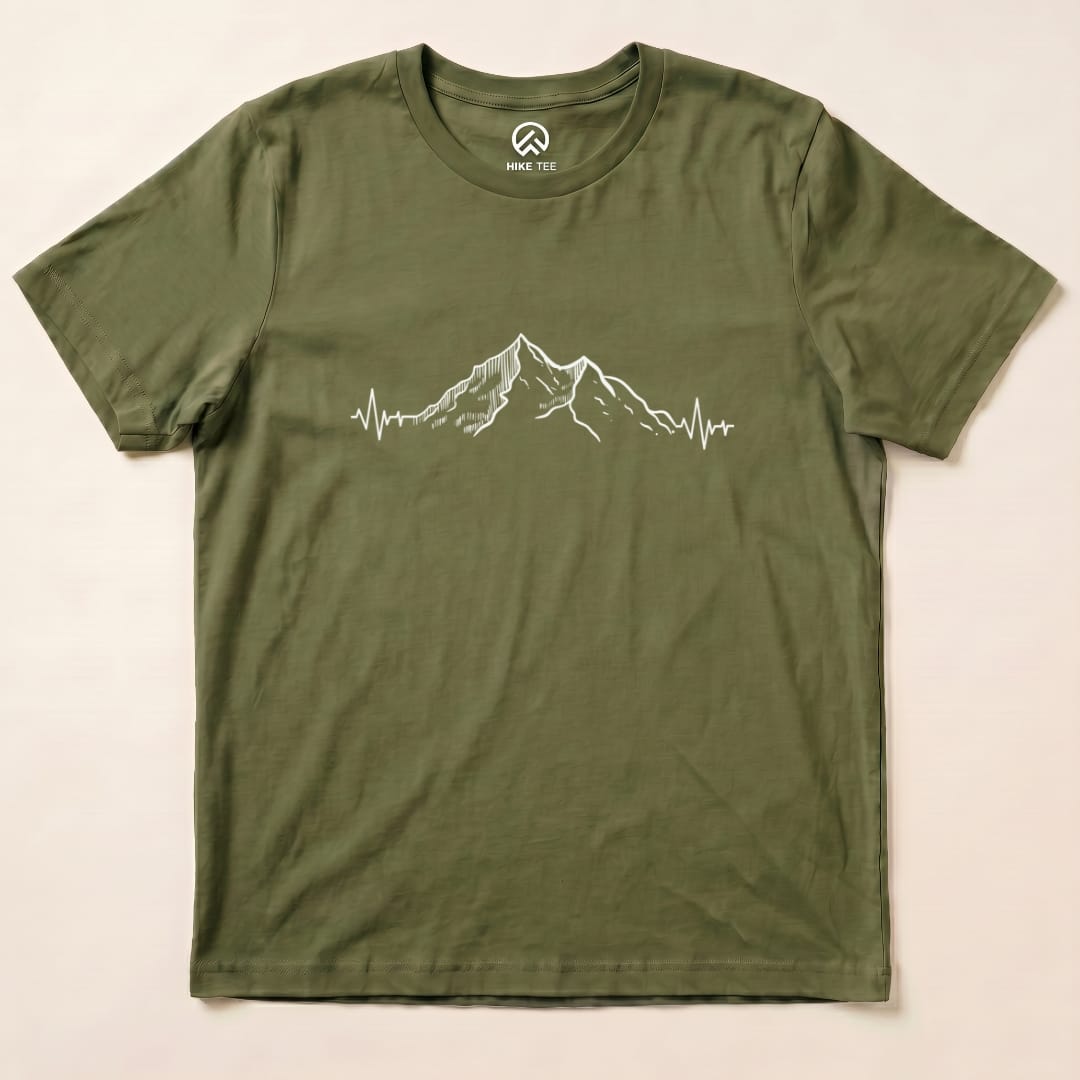 A graphic t-shirt in olive green featuring a mountain design with a heartbeat line underneath, labeled "Mountains Heart Rate Shirt".