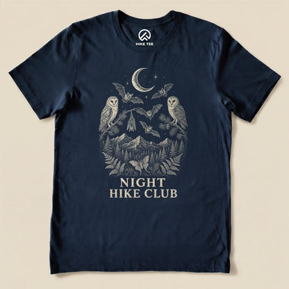 Navy graphic t-shirt featuring the "Night Hike Club Engraved Shirt" design with owls, bats, mountains, and foliage.