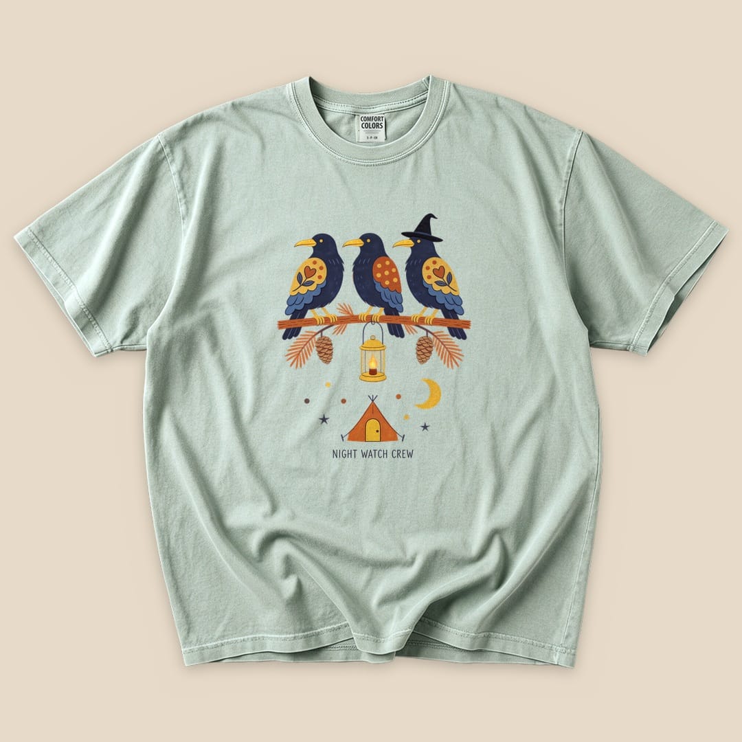 The Night Watch Crew T-Shirt features a graphic of three birds on a branch with a lantern and a tent, set against a whimsical night sky.