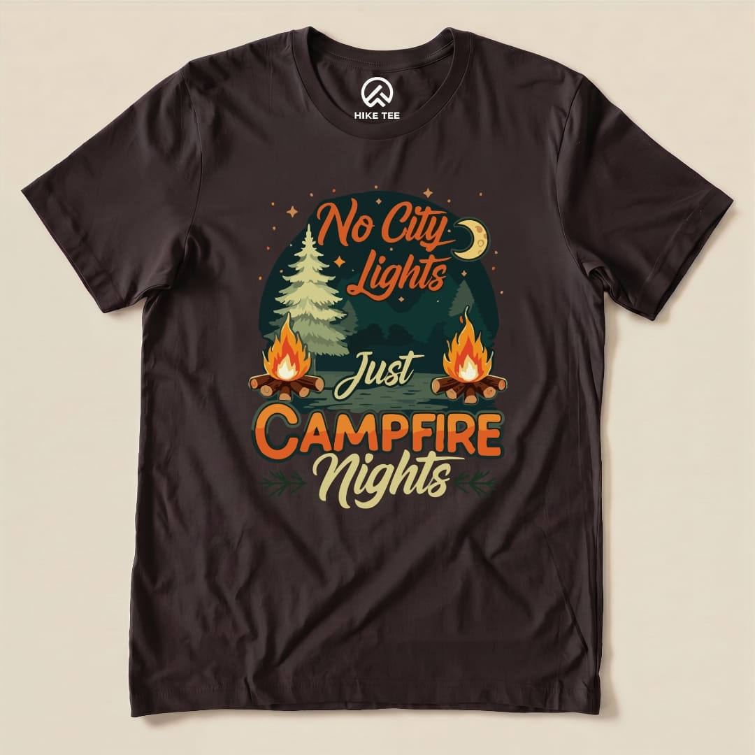 A black graphic t-shirt featuring the slogan "No City Lights Just Campfire Nights" with illustrations of trees and campfires.