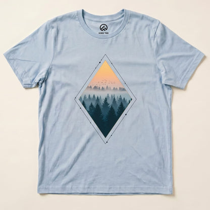 A light blue graphic t-shirt features a diamond-shaped design with a nostalgic forest scene at sunset and birds in the sky, titled "Nostalgic Forest Shirt".