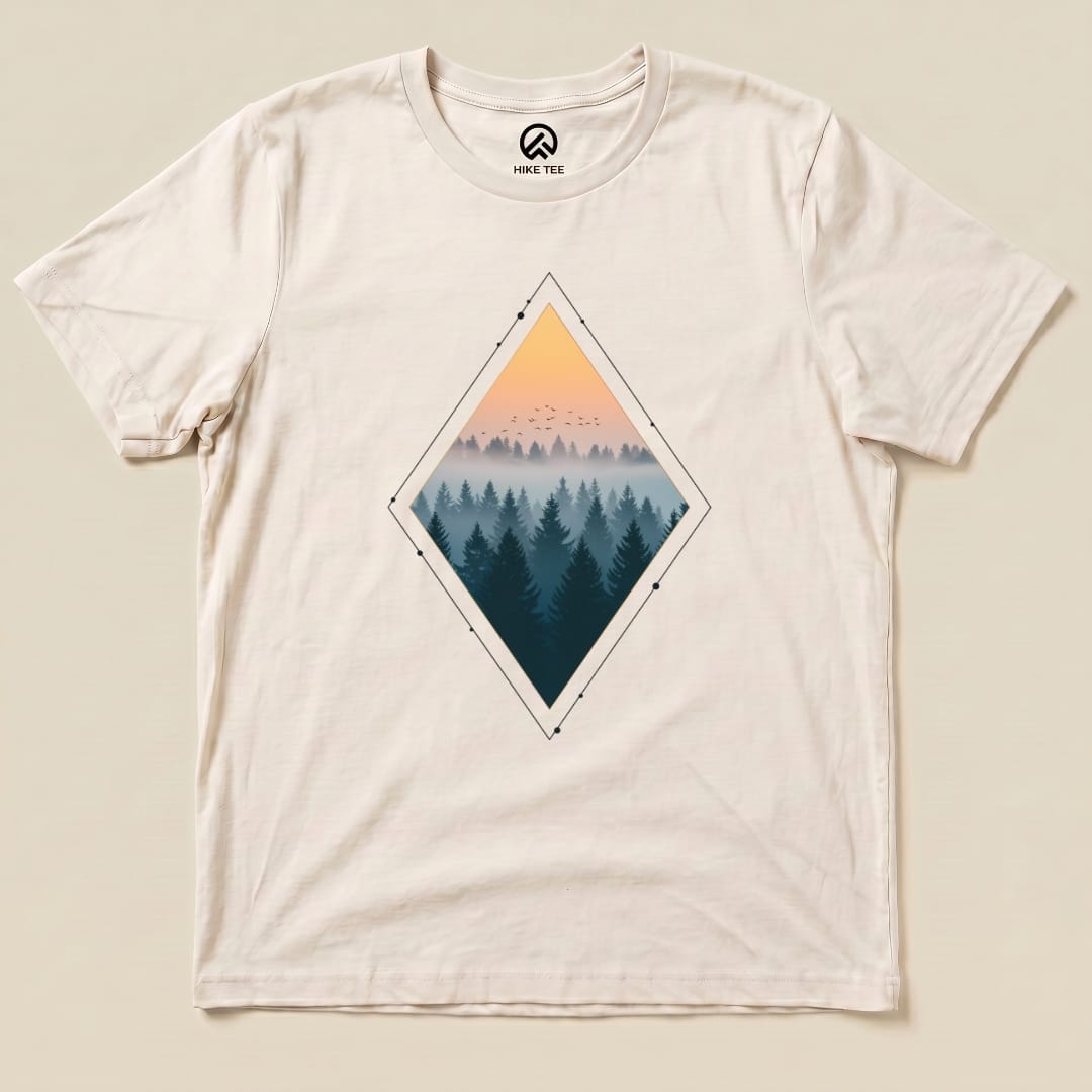 A flat lay of the graphic t-shirt features a "Nostalgic Forest Shirt" with a diamond graphic showing a misty forest at sunset.