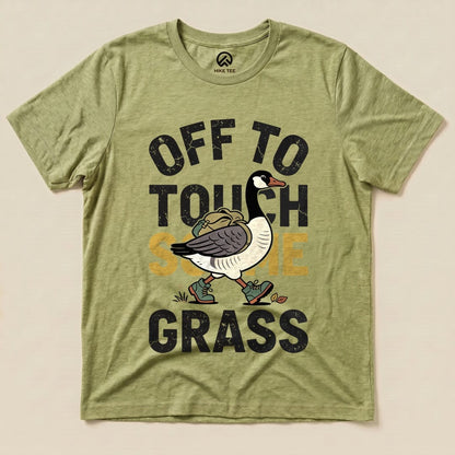 A graphic t-shirt featuring a walking goose with the text "OFF TO TOUCH SOME GRASS" in bold letters on an olive green background.