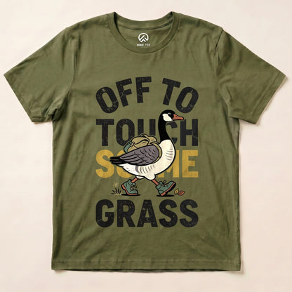 Olive green graphic t-shirt featuring a quirky goose illustration and the text "OFF TO TOUCH SOME GRASS" in bold letters.