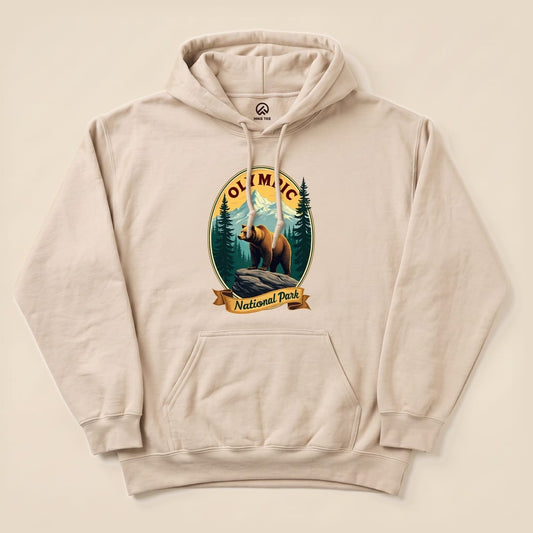 A beige hoodie featuring a graphic of a bear on a rock, with "Olympic National Park" text and surrounding forest details.