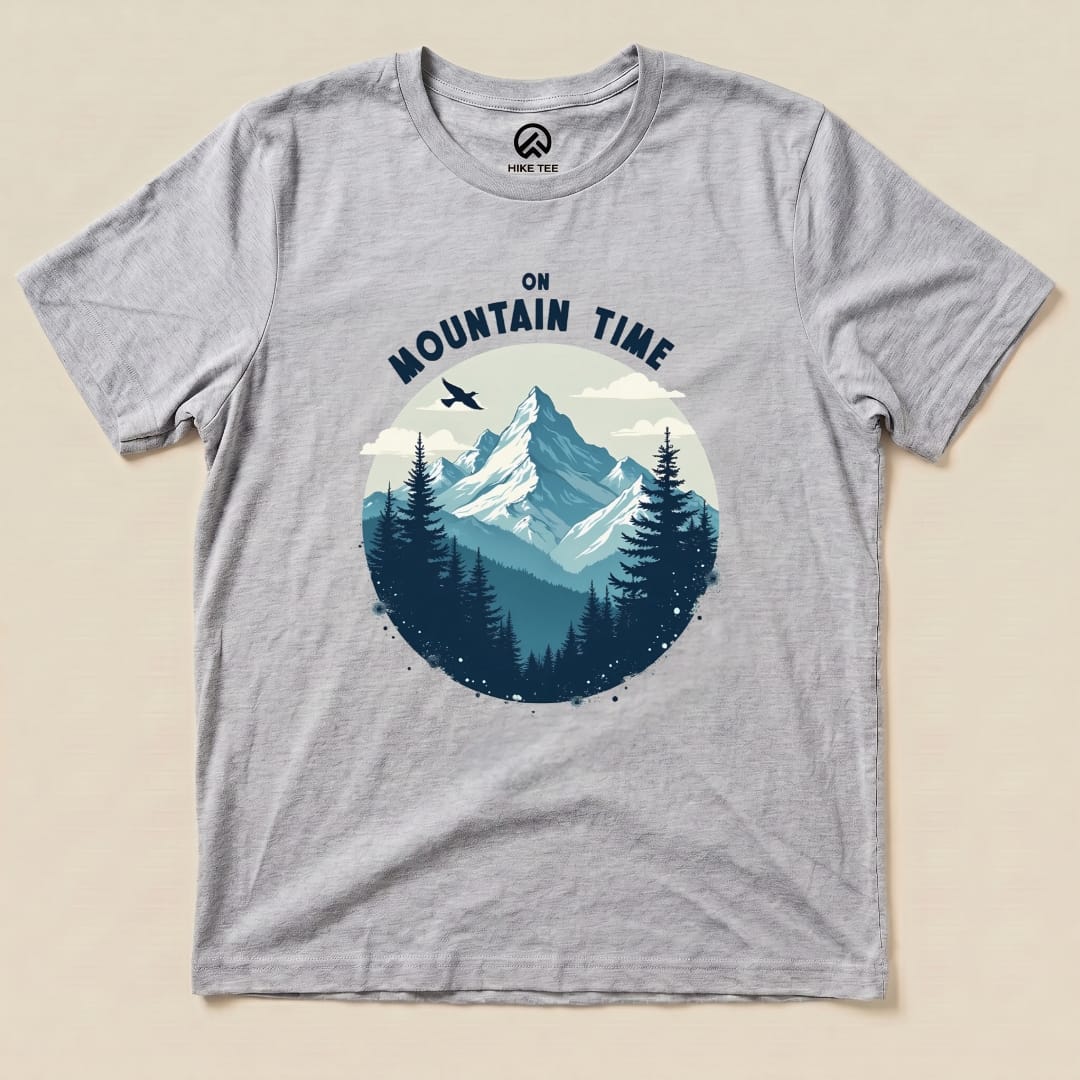 A gray graphic t-shirt featuring a mountain scene with the words "ON MOUNTAIN TIME" arching above the design.