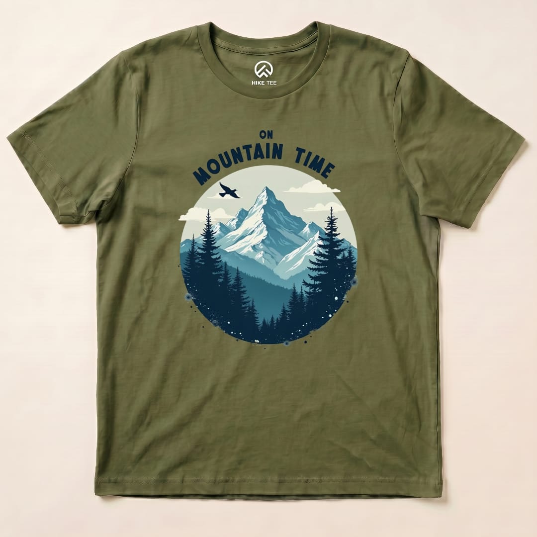 Graphic t-shirt featuring a mountain landscape with the phrase "On Mountain Time" above, set against an olive green background.