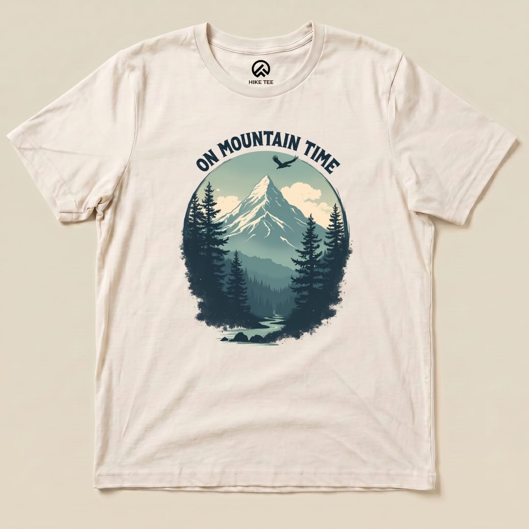 The "On Mountain Time Shirt" features a scenic mountain design surrounded by trees and the slogan, printed on a light-colored graphic t-shirt.