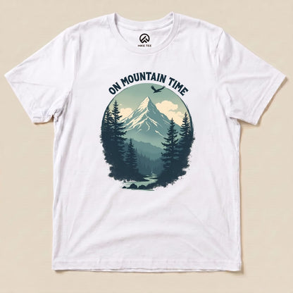 A white graphic t-shirt features a mountain scene with the slogan "ON MOUNTAIN TIME" above a serene forest landscape.