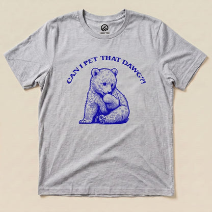 A flat graphic t-shirt in light gray featuring a blue illustration of a bear with the text "CAN I PET THAT DAWG?!".