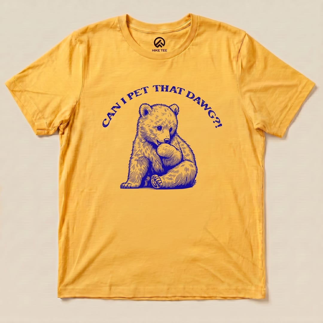 A yellow graphic t-shirt featuring a bear with the phrase "CAN I PET THAT DAWG?!" in blue lettering.