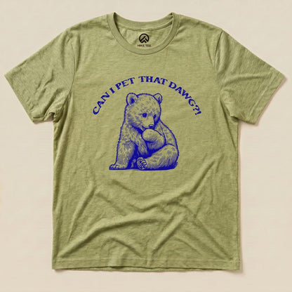 The "Pet That Dawg Shirt" features a graphic of a playful bear cub holding a rock, with the words "CAN I PET THAT DAWG?!" above it, on a light green t-shirt.